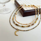 Collier à trois rangs de perles avec pendentif lune en cristal 