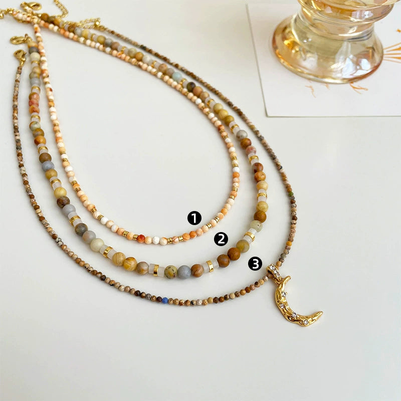 Collier à trois rangs de perles avec pendentif lune en cristal 